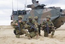Japanische Marineinfanteristen vor einem amphibischen Landungsfahrzeug AAV7A1.