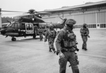 Beamte der Spezialeinheiten der Landespolizei Schleswig-Holstein vor einem Hubschrauber.
