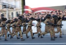 Italienische Bersaglieri im Laufschritt bei einer Parade in Lettland.