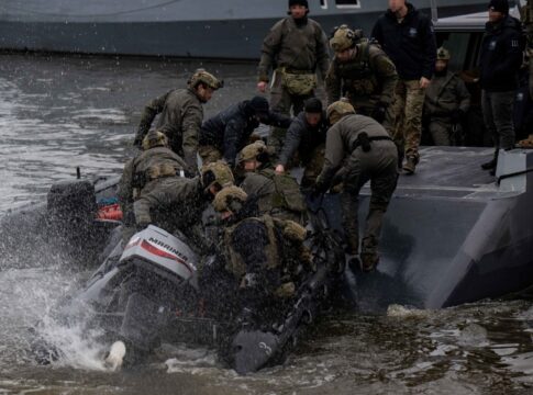 Ein Combatant Craft Medium der U.S. Navy nimmt SEALs mit einem Schlauchboot auf.