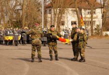 Generalleutnant Alfons Mais (l.) und Generalmajor Andreas Henne (m.) entrollten die neue Truppenfahne der Heimatschutzdivision.