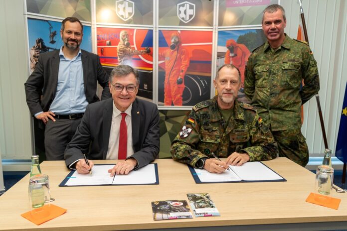 BBK-Präsisent Ralph Tiesler (li.) und der Kommandeur des ABC-Abwehrkommandos, Oberst Stephan Saalow, unterzeichnen die Kooperationsvereinbarung. Dahinter: Dr. Tobias Plate (BMI) und Generalleutnant Gerald Funke (Befehlshaber UstgKdoBw).