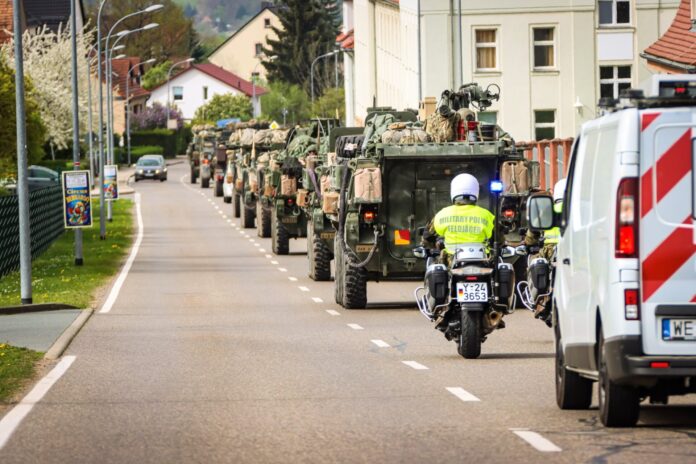 Feldjägerwesen der Bundeswehr: Kolonnen US- amerikanischer Gefechts- und Versorgungsfahrzeuge rollen während der Übung Quadriga 24 begleitet von Feldjägern durch Frankenberg in Hessen.