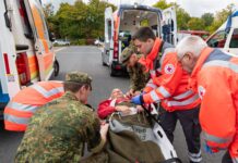 Soldaten vom Sanitätsregiment 2 der Bundeswehr übergeben bei einer Übung einen versorgten Patienten an das Deutsche Rote Kreuz.