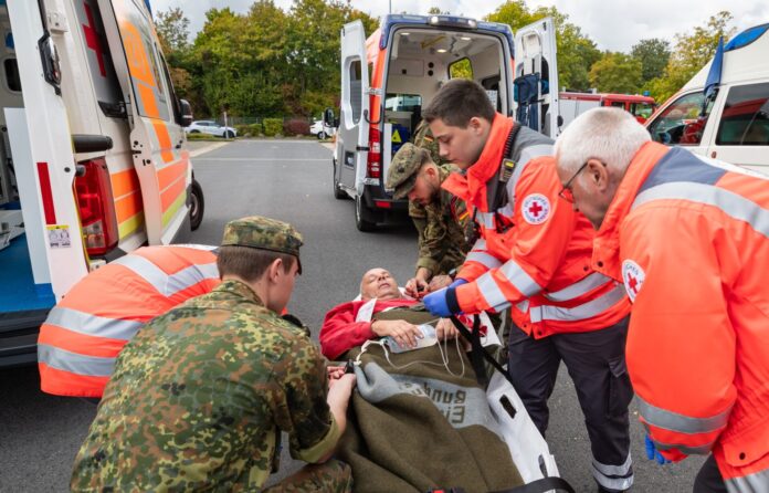 Soldaten vom Sanitätsregiment 2 der Bundeswehr übergeben bei einer Übung einen versorgten Patienten an das Deutsche Rote Kreuz.