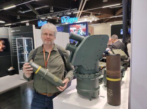 APS Iron Fist: Elbit bietet Produktion in Deutschland an 7 S&T-Redakteur Stefan Axel Boes mit der Wirkkörper-Patrone von Iron Fist neben dem zweirohrigen Werfer und der Transporthülse für den Effektor.