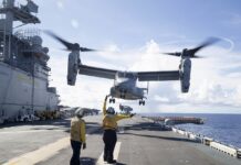 Ein MV-22 Osprey Kipprotorflugzeug des U.S. Marine Corps (USMC) über dem Amphibienträger USS Tripoli.