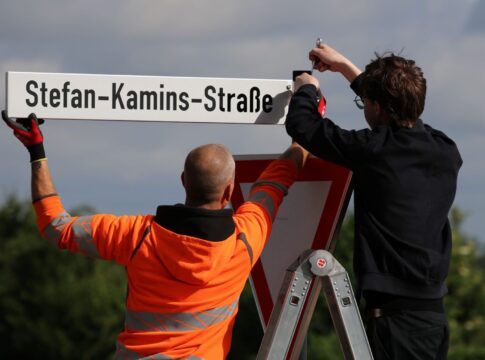 Maximilian Koller, Neffe von Stefan Kamins (r.) brachte das neue Straßenschild an der Zufahrt zur Mercator-Kaserne in Euskirchen an.