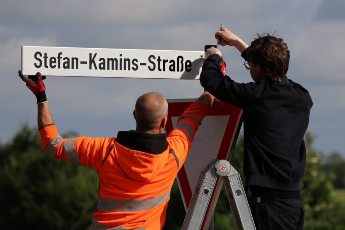 Maximilian Koller, Neffe von Stefan Kamins (r.) brachte das neue Straßenschild an der Zufahrt zur Mercator-Kaserne in Euskirchen an.